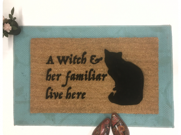 a witch and her familiar live here black cat halloween gothic home doormat